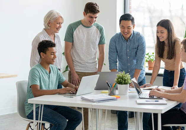 Colleagues collaborating over laptops around a modern desk space